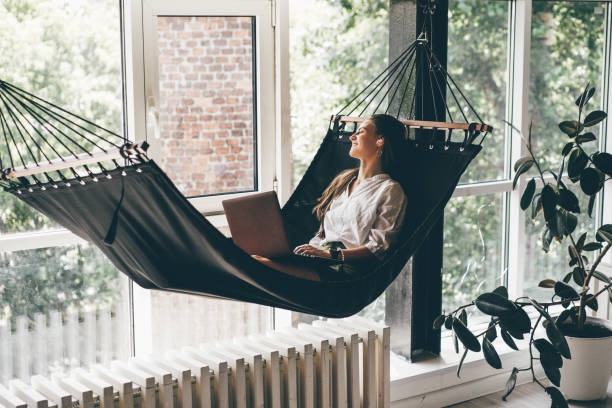 Student working on a hammock, representing relaxation and self care in a flexible work environment