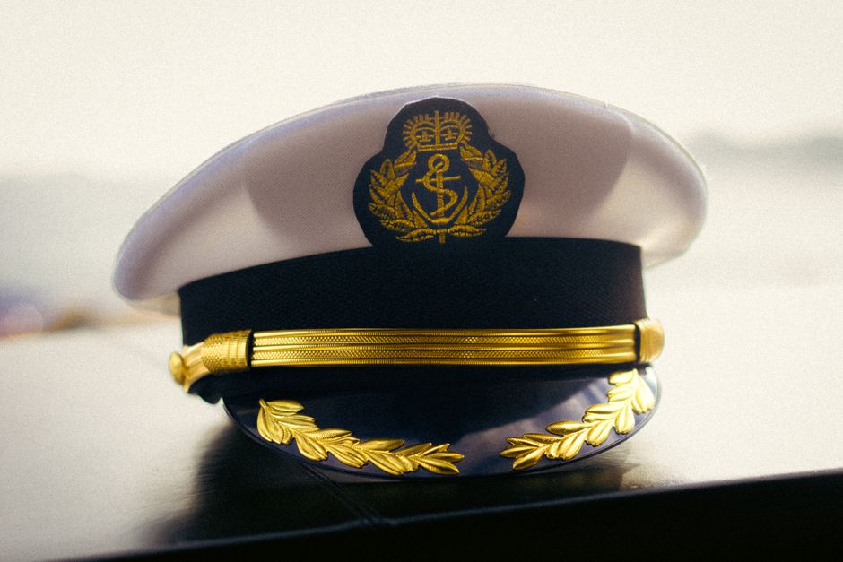 A close-up of a military cap and insignia resting on a surface.