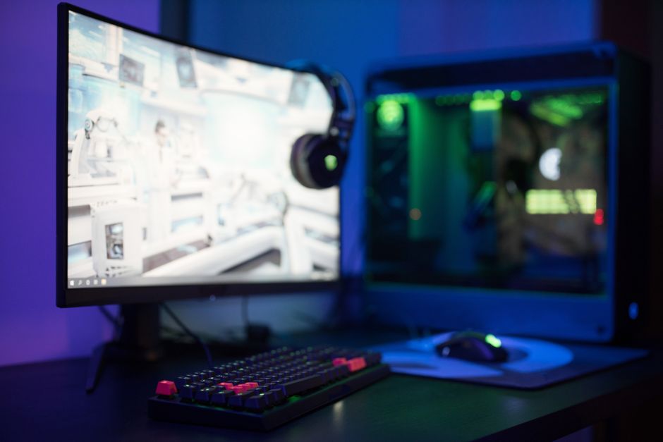 a computer monitor and PC in a dimly lit room