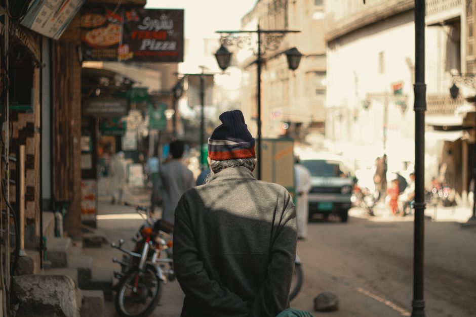 A street view in Peshawar with people and shops, capturing local culture and daily life.