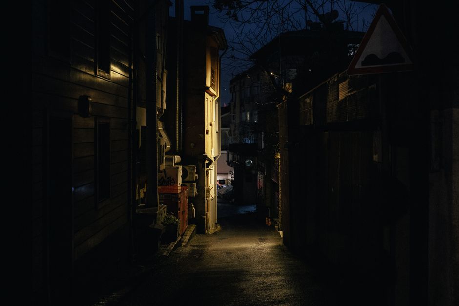 Dimly lit narrow alleyway at night, showcasing urban architecture and eerie atmosphere.