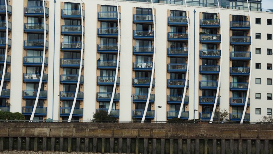 Contemporary apartment block with blue balconies and unique facade design.
