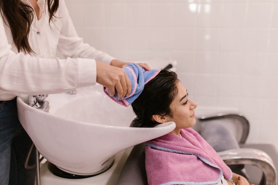 A woman enjoys a relaxing hair wash at a modern hair salon, emphasizing self-care and pampering.