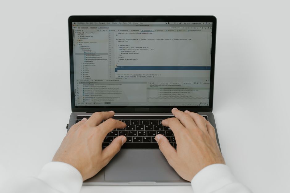 Close-up of hands coding on a laptop, showcasing software development in action.
