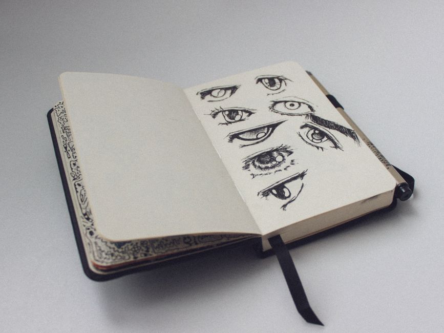 A sketchbook open to a page with artistic eye drawings, showcasing detailed sketches.