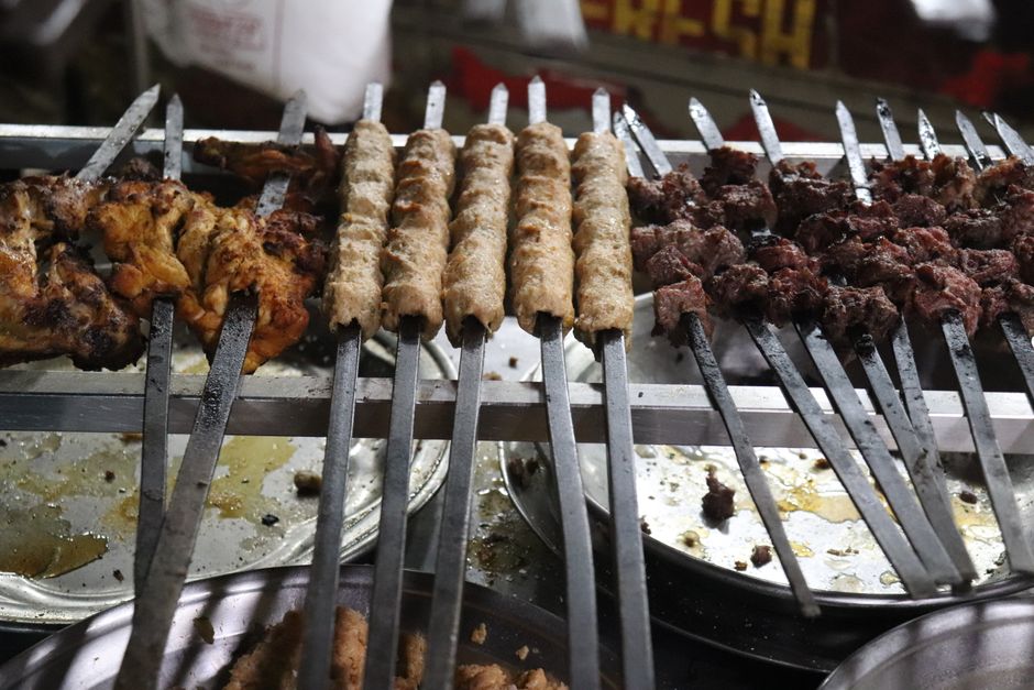 A tempting display of traditional Pakistani kebabs and grilled chicken skewers at an outdoor market in Karachi.