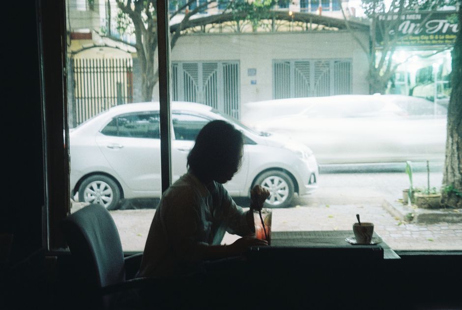 Silhouette of a person in a cafe with a street view in Ho Chi Minh City, Vietnam.