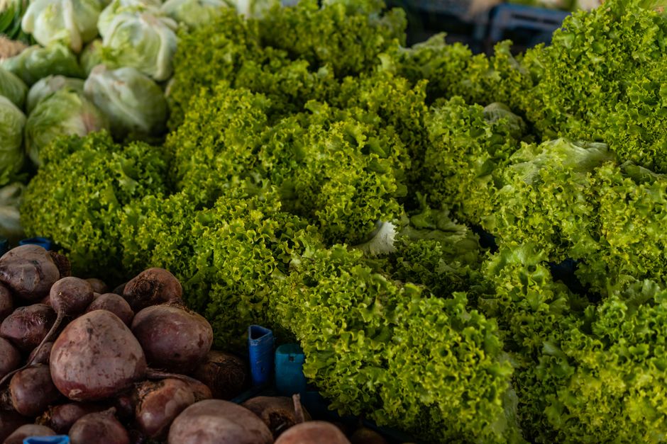 Close-up of various fresh vegetables including lettuce and beets at a market.
