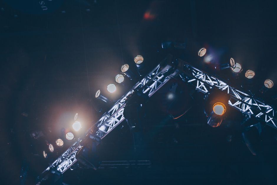 Bright stage lights illuminate a concert venue, creating a vivid and celebratory atmosphere.