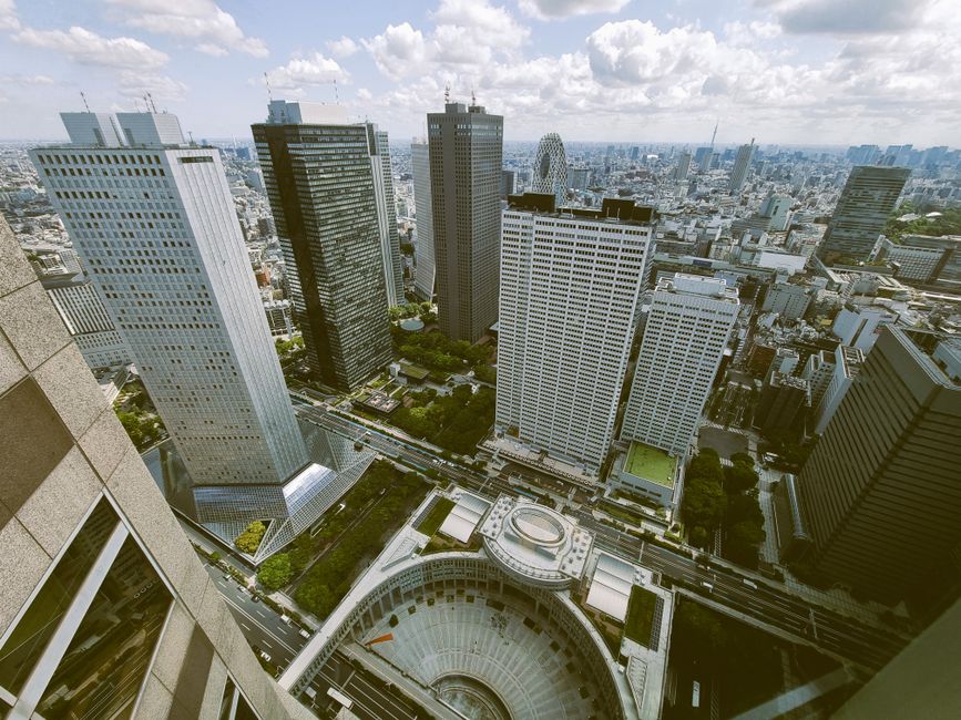 A stunning aerial shot of Tokyo's Shinjuku district showcasing iconic skyscrapers under a bright sky.