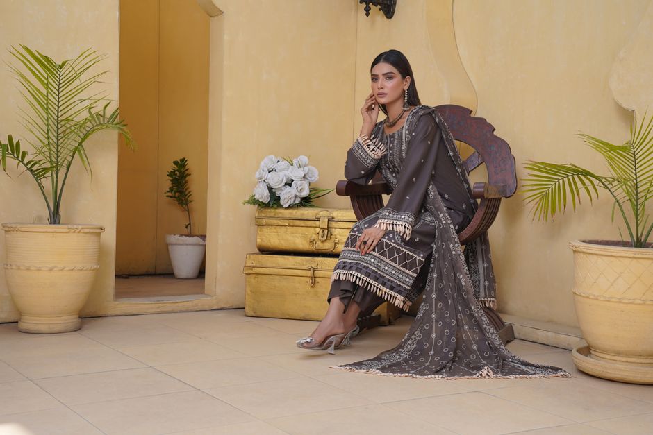 A stylish woman in traditional Pakistani attire seated elegantly indoors in Lahore.