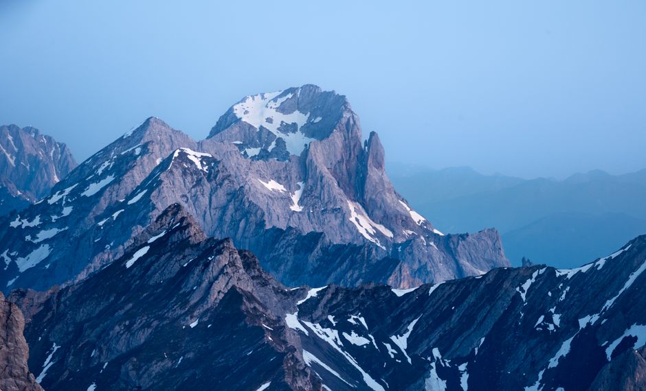 Stunning view of snow-capped alpine mountains at sunrise, showcasing nature's grandeur.