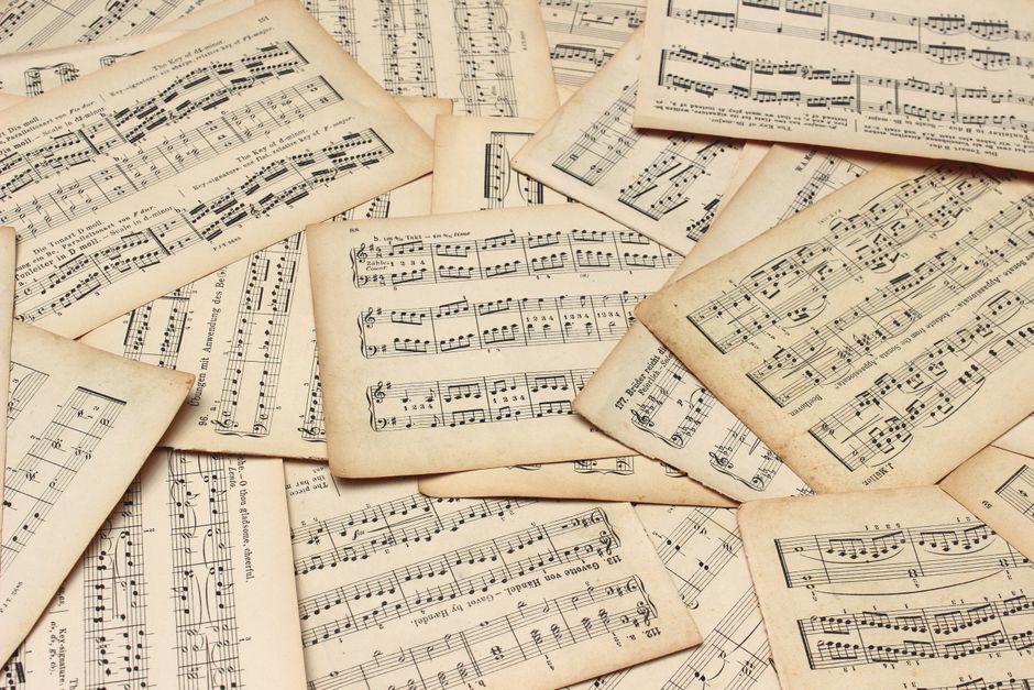 A collection of vintage music sheets scattered artistically, showcasing classic musical notation.