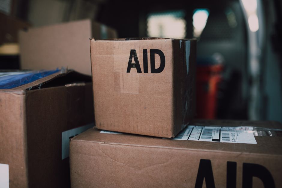 Stacked aid boxes ready for distribution in a delivery vehicle.
