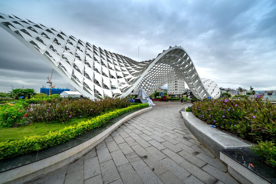 Striking pavilion structure with geometric design in a cityscape, offering a blend of nature and architecture.