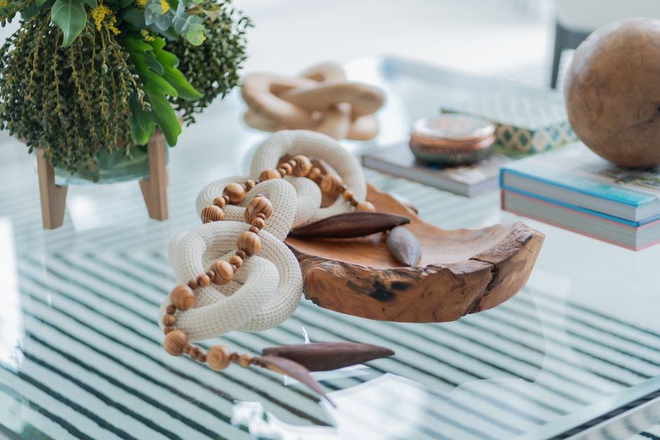 Stylish handmade decor with wooden and rope elements on a glass table, adding charm to modern interiors.
