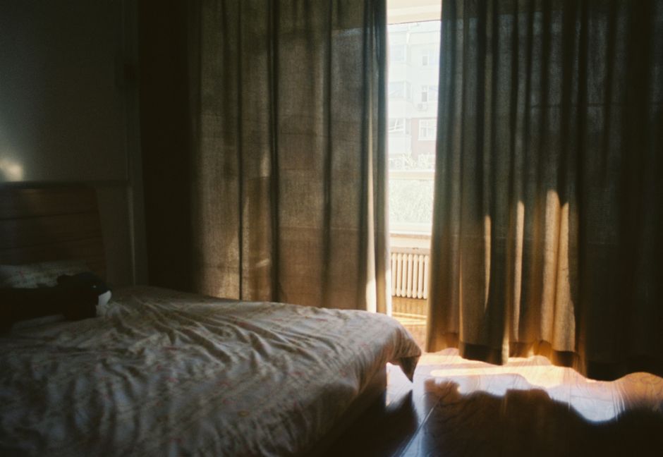 Warm bedroom featuring sunlit curtains and a peaceful, cozy ambiance.