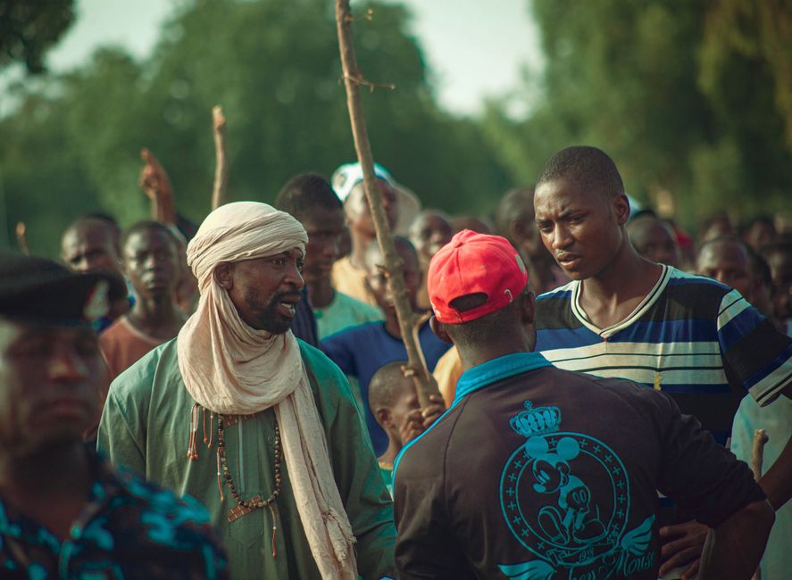 A lively outdoor gathering with people interacting in a vibrant community setting.