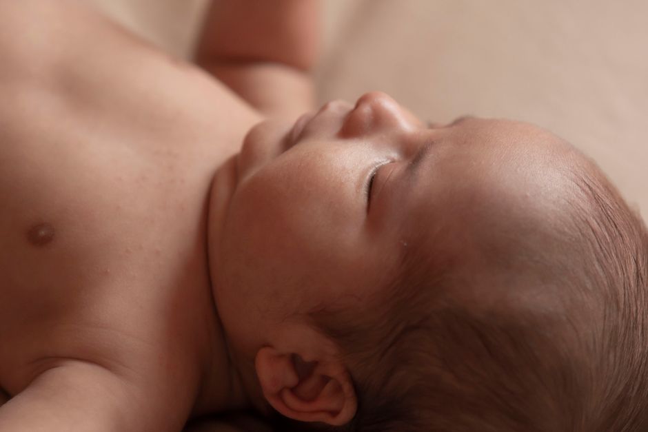 A serene close-up photograph capturing the peaceful innocence of a newborn baby sleeping.