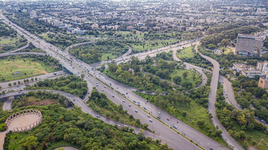 Aerial shot of Islamabad's intricate expressway system, showcasing lush greenery and urban development.