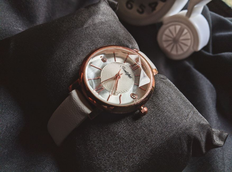 Close-up of a stylish rose gold wristwatch showcasing luxury and fashion on a black pillow.