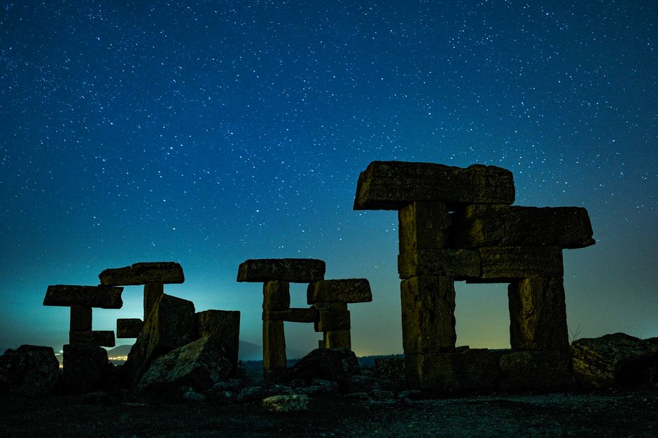 Explore ancient ruins in Uşak, Türkiye, set against a breathtaking starry night sky.