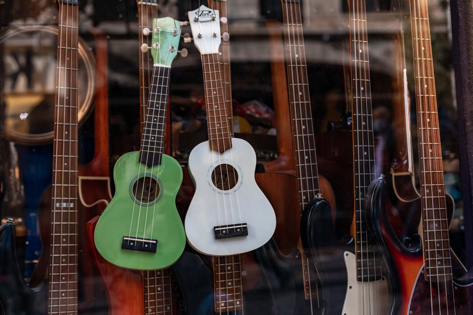 Shop window showcasing a collection of colorful ukuleles and guitars.