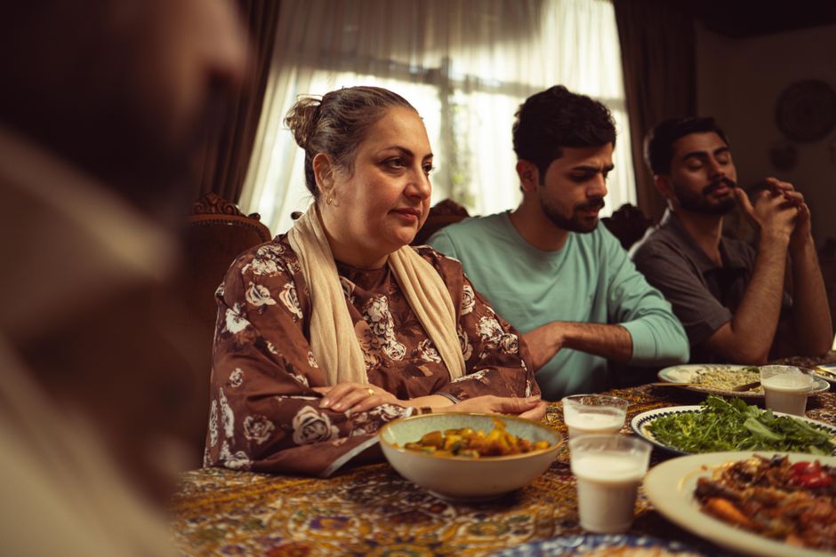 A heartwarming family scene enjoying a meal together indoors, showcasing cultural unity.
