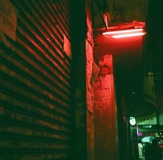Explore the atmospheric neon-lit alleyway in Kowloon, Hong Kong, showcasing a cyberpunk aesthetic.