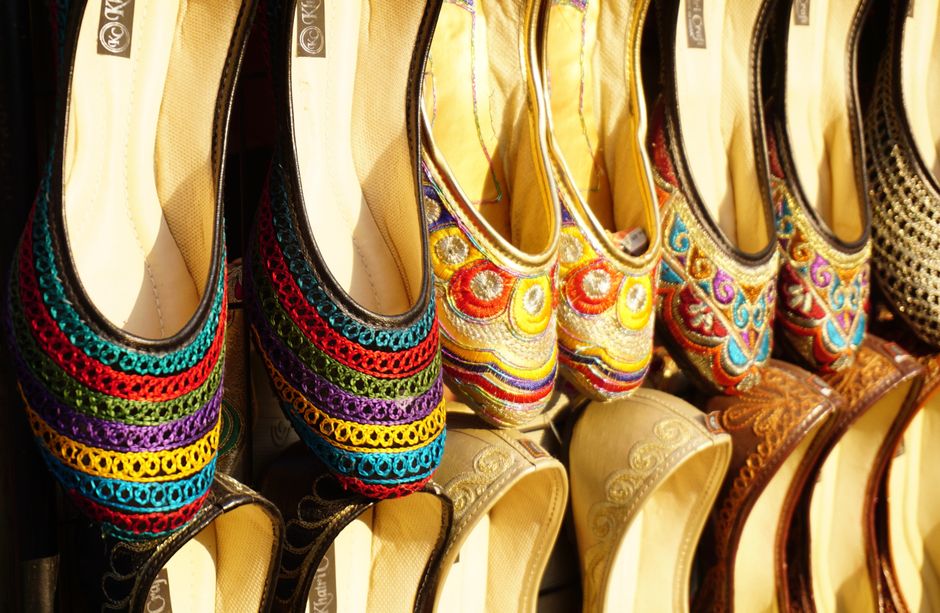 A vibrant collection of embroidered handmade shoes showcasing intricate traditional designs.