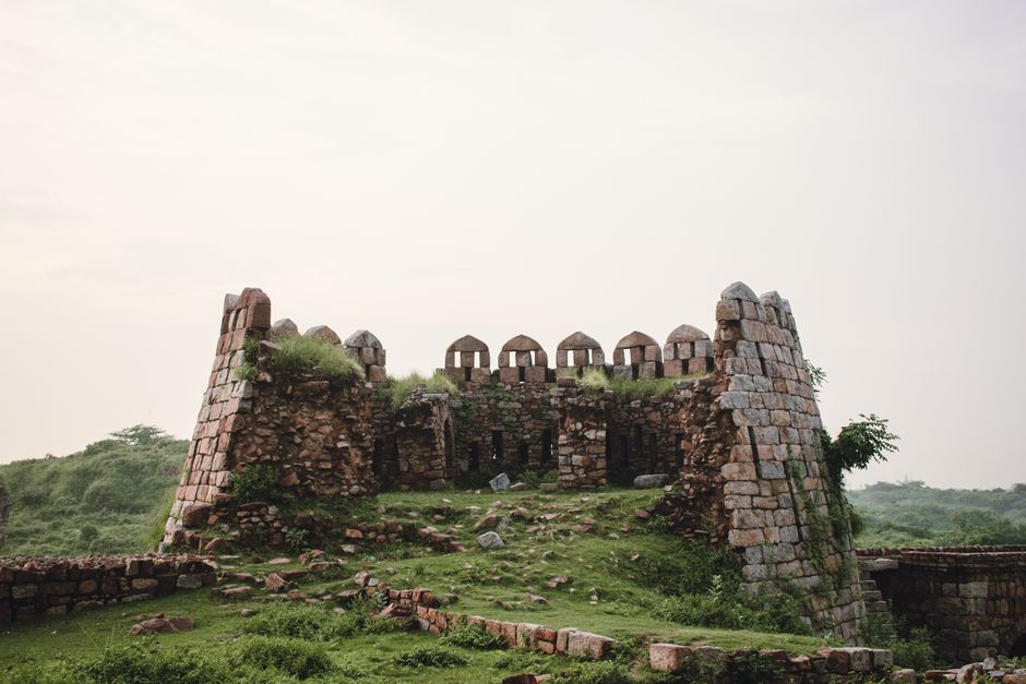 Explore these ancient stone fort ruins nestled on a lush green hill, capturing a glimpse of history.