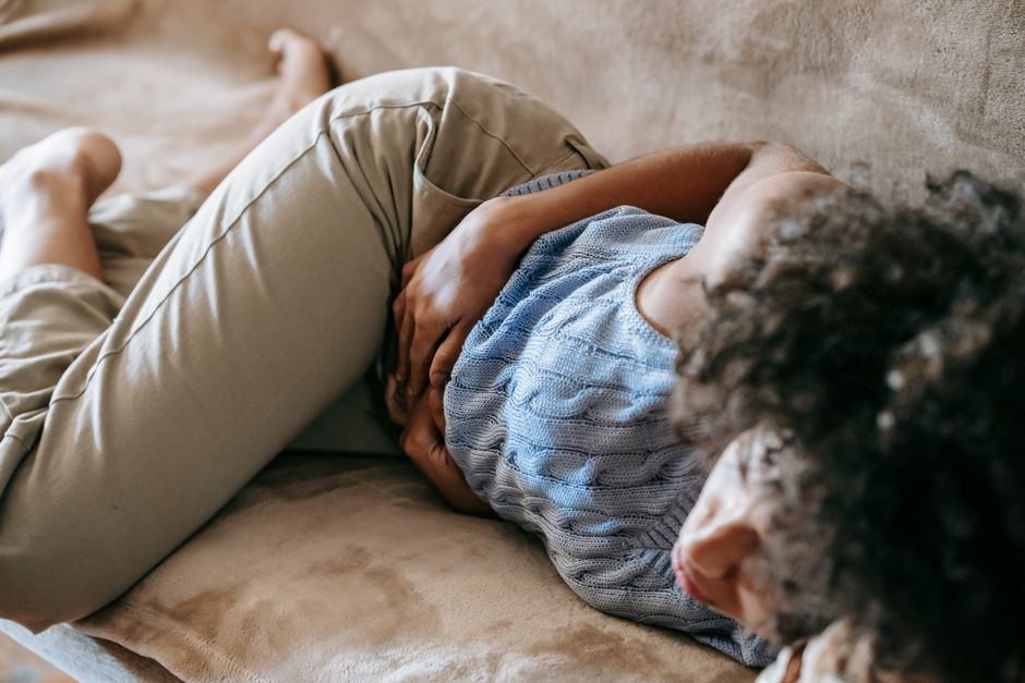 Person holding stomach in discomfort.