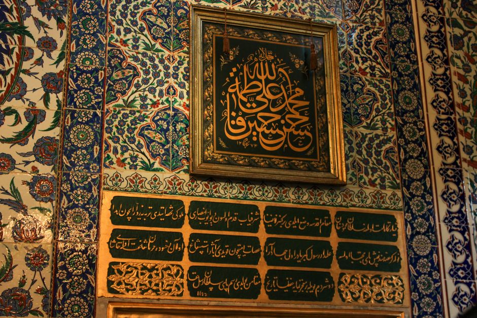 Ornate Islamic calligraphy and colorful tile patterns in a historic setting.