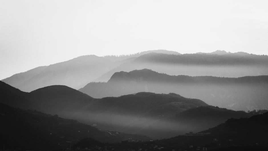 Stunning black and white mountain scene with mist creating a dramatic atmosphere.