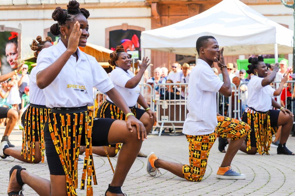 Energetic group dance performance at a vibrant street festival.