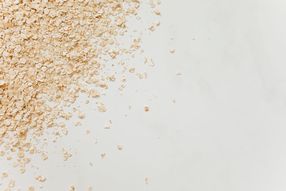 Close-up of scattered oatmeal on a clean white background, perfect for food-related themes.