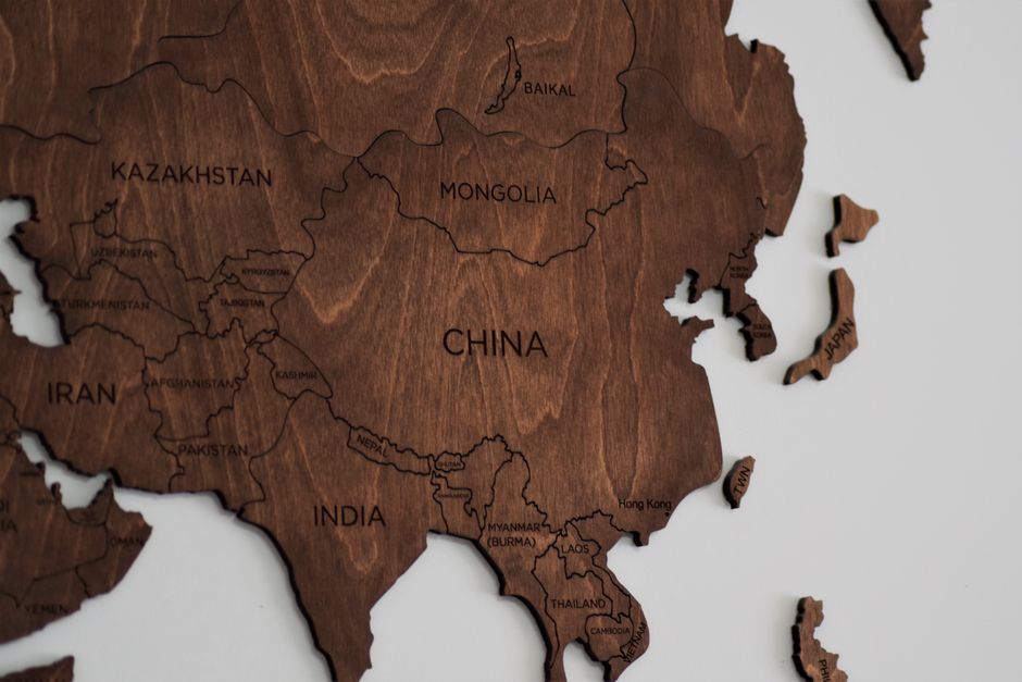Close-up view of a detailed wooden map of Asia, showing countries like China and India.