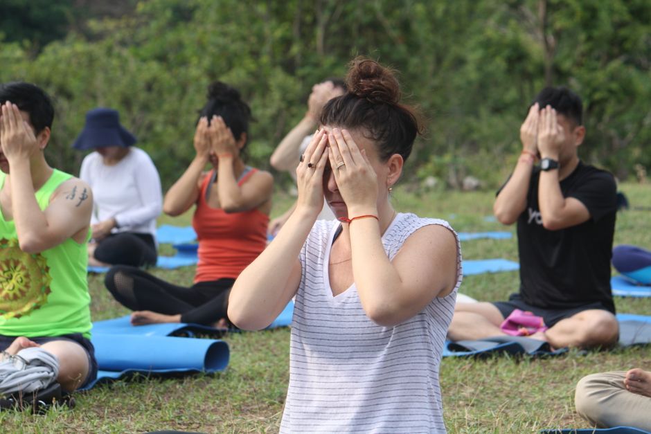 Group practicing yoga meditation outdoors at a retreat in Rishikesh, India.
