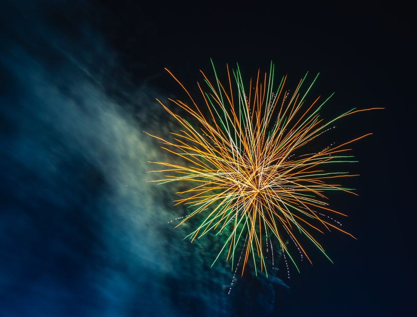 A colorful explosion of fireworks brightens the dark night sky, creating a festive atmosphere.