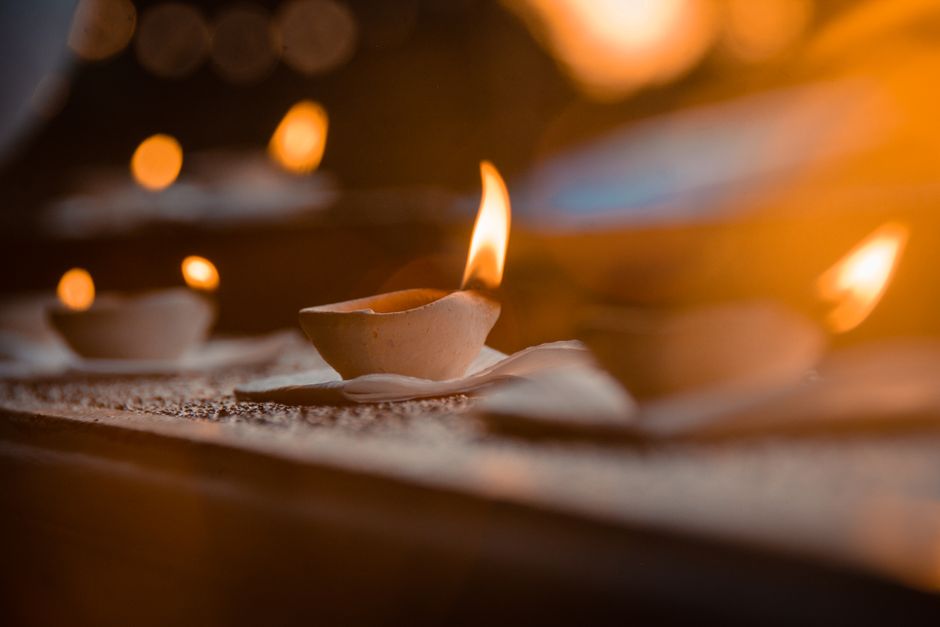 Close-up of burning candles with a warm glow and soft bokeh effect, creating an intimate ambience.