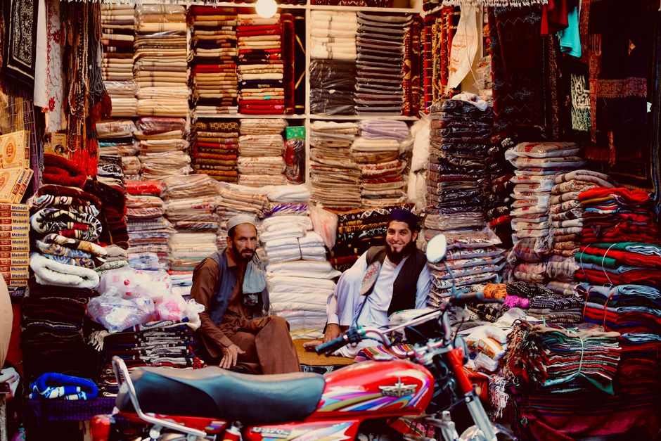Vibrant textile market showcasing diverse fabrics with two smiling sellers.