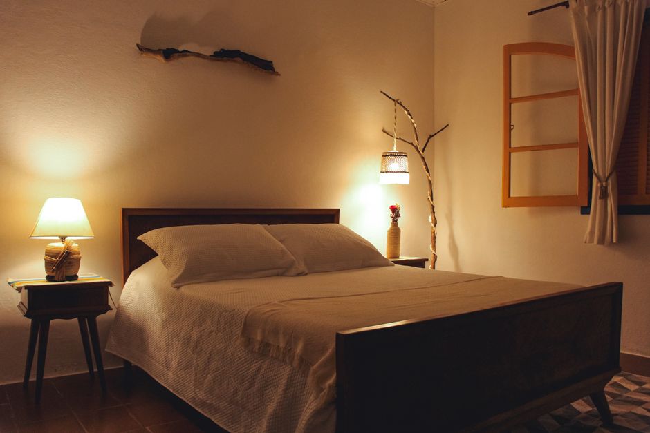 Inviting bedroom with a warm glow, wooden bed, and rustic decor.