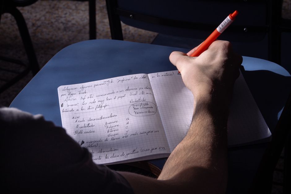 Depression, Anxiety A student takes notes in a classroom in Buenos Aires. Natural lighting highlights the writing process.