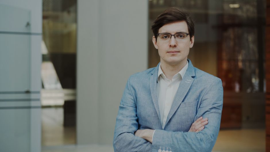 Portrait of a confident businessman in a blue suit posing indoors.